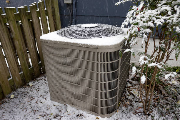 Snow-covered outdoor HVAC unit in winter